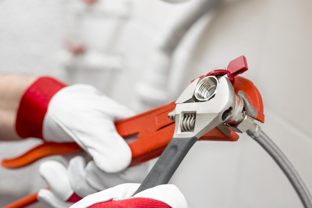 Plumber holding pipe wrenches for an emergency repair in Sanford