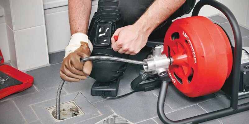Plumber using a drain-cleaning machine in Sanford