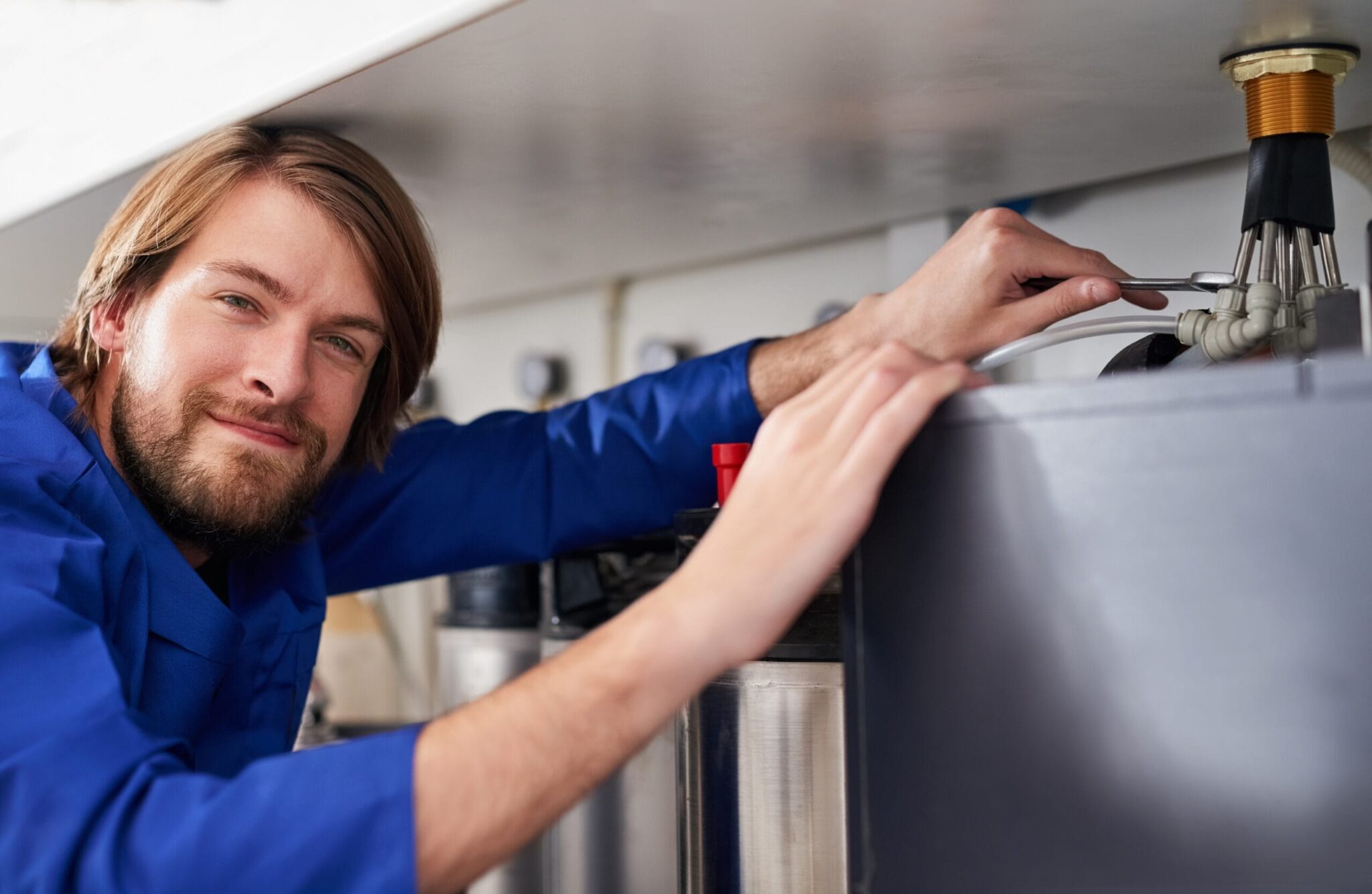 Technician servicing a residential water heater tank in Sanford